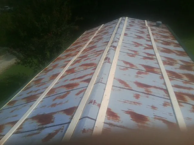 Rusted metal roof panels with new wood purlins before replacement — Storm Damage Roof Repair in Kennard by Roofing Brothers