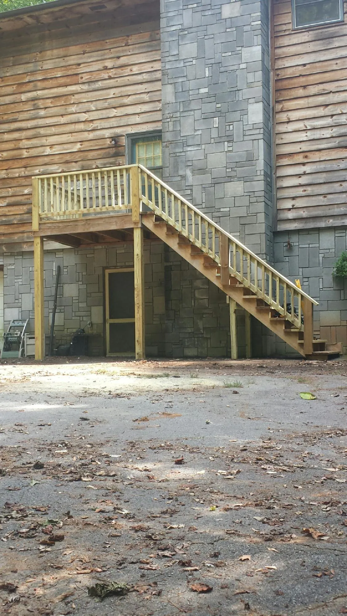 New pressure treated deck and stair landing on a log home in Kennard