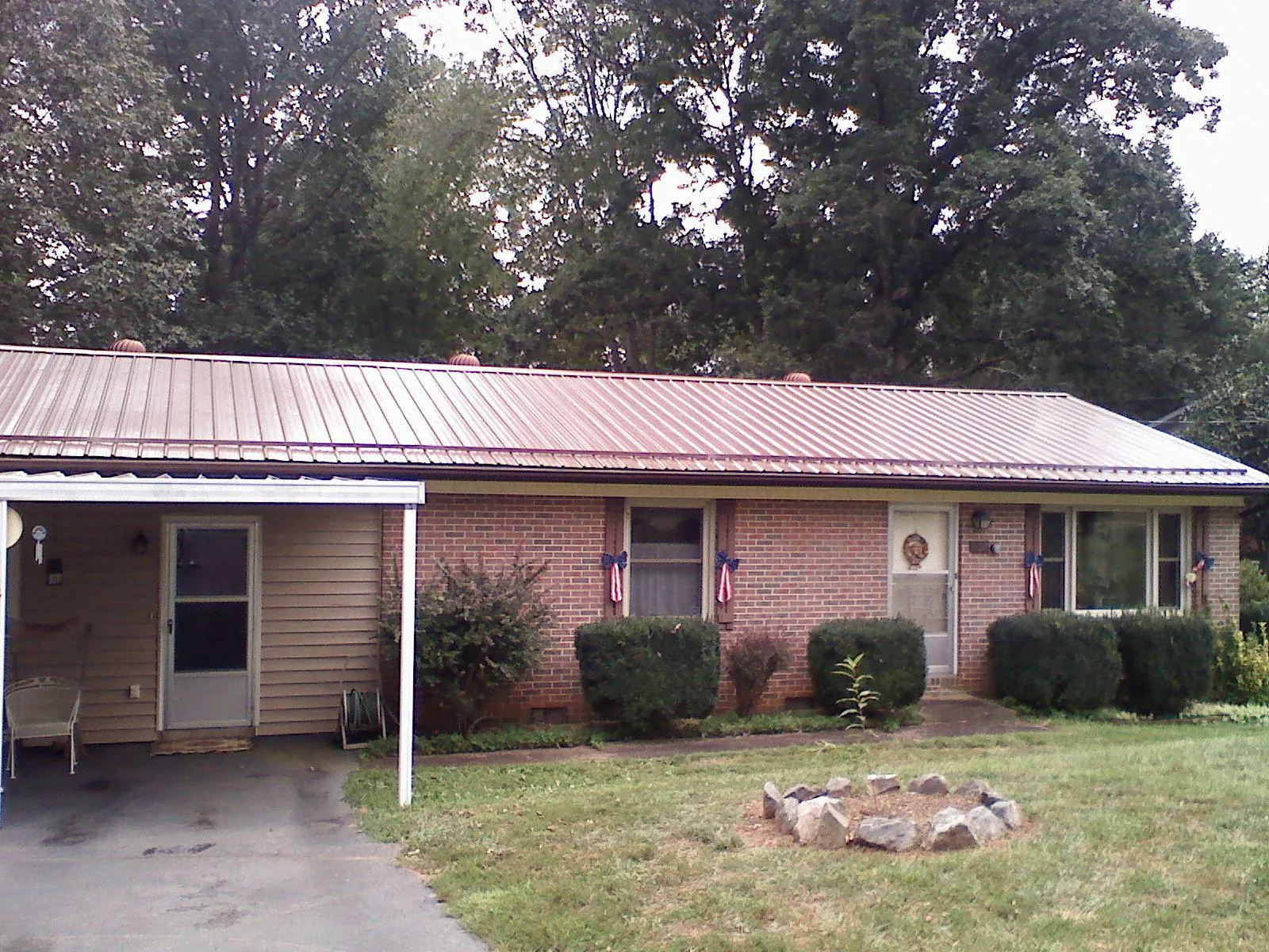 Bronze metal roof and carport on a brick ranch home — Roof Repair work by our crew in Kennard
